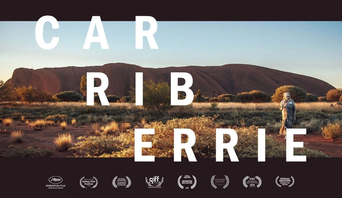 Carriberrie landscape poster: a lone performer before Uluru at dusk, above a row of film festival laurels
